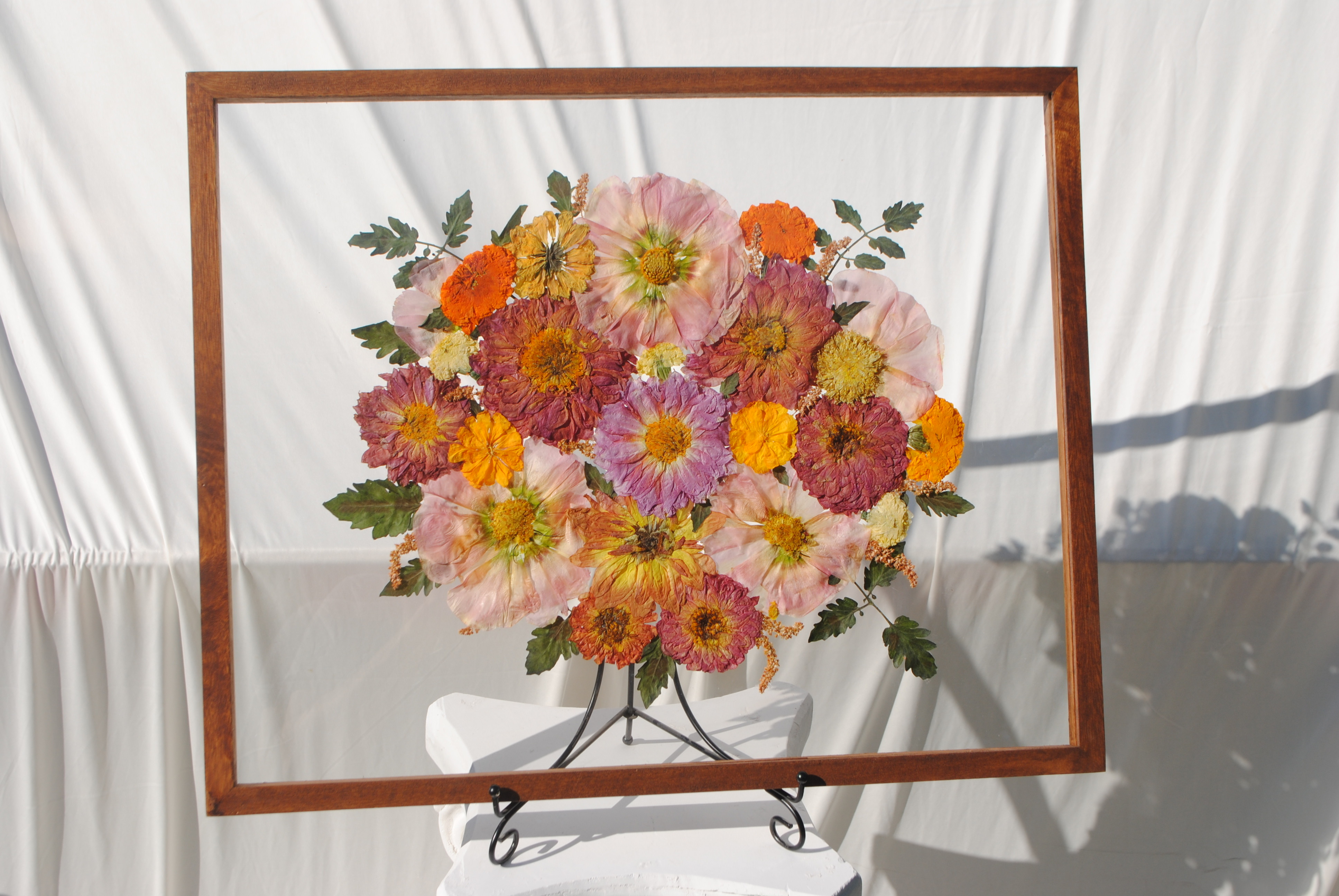 Vibrant pressed flower arrangement sealed in glass frame for step three
